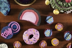 Image donuts and cupcakes in blue and pink shades on a wooden table