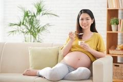 Pregnant woman eating yogurt