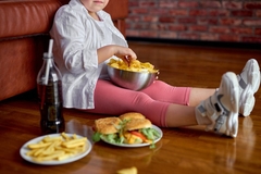 Image Child eating chips and surrounded by junk food.