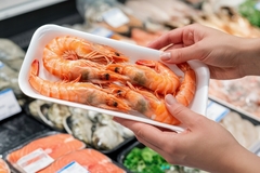 A shopper buying shrimp.