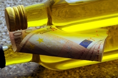 Image two olive oil bottles lying down with euro notes