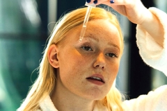 Image A woman putting a serum on her face.