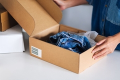 A person holding a box of clothes