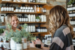 A woman checking out at a beauty shop with the worker.
