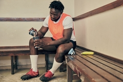 Image a young athlete pouring protein powder in a shaker