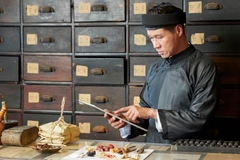 Image Traditional medicine practitioner using tablet