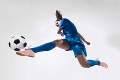 Image female athlete in air kicking football