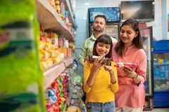 Image girl with parents reads food label in grcoery asile