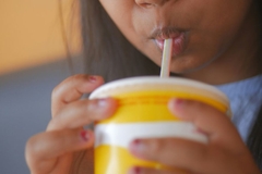 A close-up of a child drinking from a straw