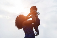Image mother holding child in the air