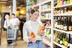 Image A shopper examining a wine label.