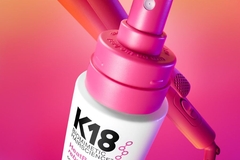cosmetics bottle in front of a bright pink backdrop