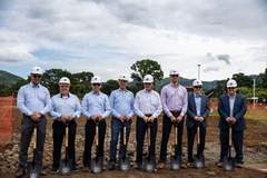 A group of men wearing white helmets holding shovels
