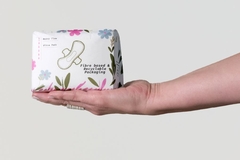 Image A person holding a small package of sanitary pads