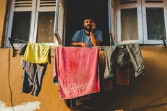 Image man next to hanging laundry