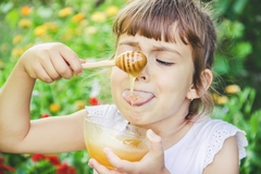 young girl eating honey