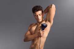 A man using at at-home laser on his armpits.