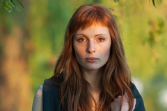 Image woman with red hair standing in the sunlight