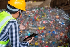 Image man holding plastic bottle in factory