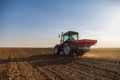 Tractor using fertilizer in a field.