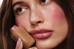Image woman holding skin care in front of face