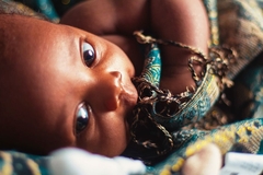 Image baby in blankets laying on surface