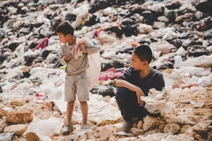 Image A child and child standing in a pile of garbage