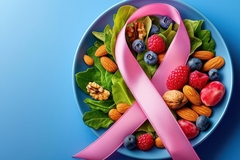 Pink breast cancer ribbon next to healthy salad