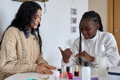 Image Two girls painting their nails together.