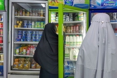 Image People in robes looking at a refrigerator