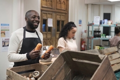 Man handing out carrots at community center