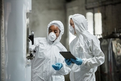 Image Two employees checking fermentation equipment
