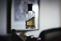 person throwing a bottle of perfume into the air
