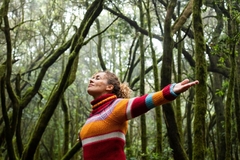 woman standing with open arms in nature