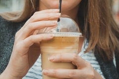 A woman drinking a frappucino.