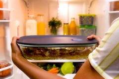 Image Placing lid-sealed glass container filled with food in fridge.