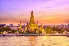 Bangkok, Thailand, with the temple by the river at sunset.