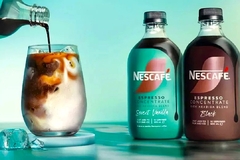 Image pouring coffee concentrate into a glass of milk