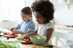 Two children making a salad