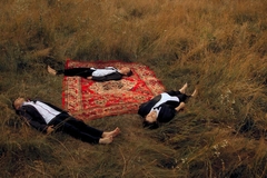 Image people laying in the field on a rug