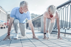 Image An older couple prepare to sprint against each other on a bridge.