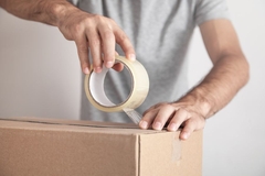 man taping cardboard box closed