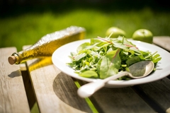 Oil and salad on a table.