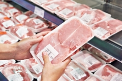 Image Person holding pork steaks.