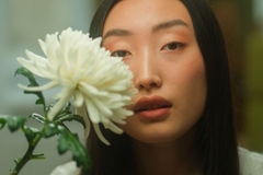 Image korean woman holding a white flower infront of her face