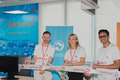 Image two men and a woman in white shirts holding a long white ribbon