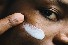 Image man applying smear of sunscreen to his face