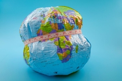 Image Earth being squeezed by measuring tape around it