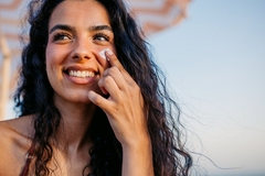 Image A girl putting sunscreen on her cheek.