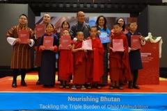 Image Bhutan PM stands with children on stage